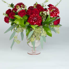 Red roses and red-white dahlias in a clear glass vase