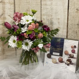 Mixed bouquet of pink roses and white daisies in a glass vase