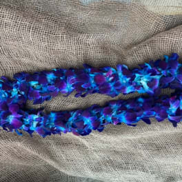 Blue and purple flower lei on burlap fabric