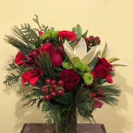 Red and white floral arrangement in a glass vase