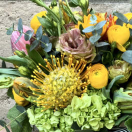 Bouquet with yellow and pink flowers and blue-green foliage