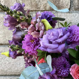 Bouquet of purple and pink flowers with blue eucalyptus leaves