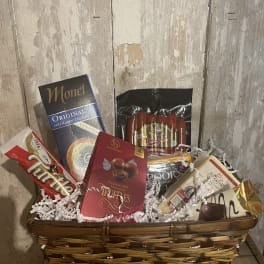 Gift basket with assorted chocolates and packaged snacks in a wicker basket