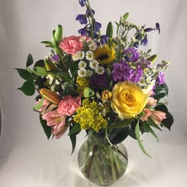 Mixed bouquet of colorful flowers in a clear glass vase