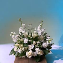 White floral arrangement with a clear glass cross centerpiece