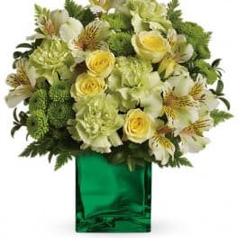 Yellow and white flowers arranged in a green glass vase