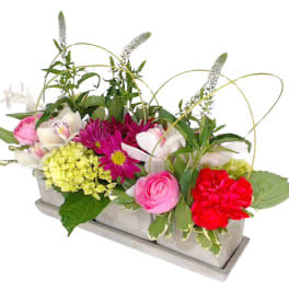 Mixed pink, white, and red flowers in a rectangular container