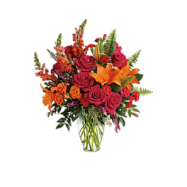Bouquet of pink roses and orange lilies in a clear glass vase