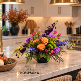 Colorful flower arrangement in a black bowl on a kitchen island