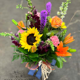 Colorful bouquet with sunflower, orange lily, and purple blooms