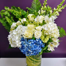 White and blue floral arrangement in a glass vase