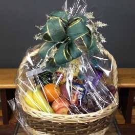 Gift basket with fruit, snacks, and a green ribbon bow