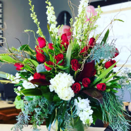 Large bouquet of red roses and white flowers in a glass vase