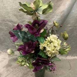Purple and cream floral arrangement in a dark vase
