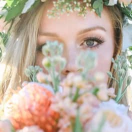 Woman wearing a floral crown and holding a pastel bouquet