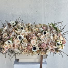 Large pastel bouquet of roses and white anemones in a rectangular vase