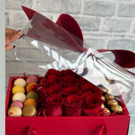 Red roses in a gift box with macarons and chocolates