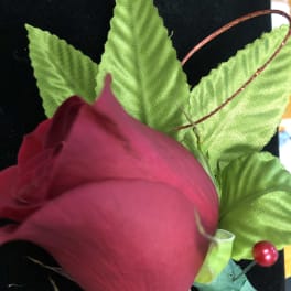 Single pink rose with bright green leaves and a decorative berry pick