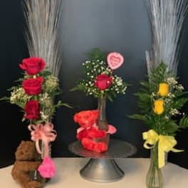 Three rose arrangements with teddy bears and ribbons
