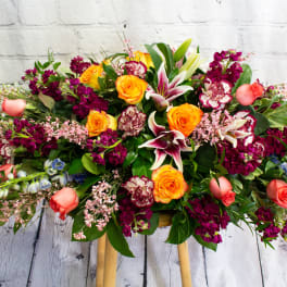 Large mixed bouquet with orange roses, lilies, and magenta flowers