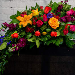 Colorful mixed bouquet with roses and lilies on a dark cloth