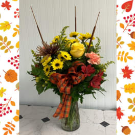 Fall bouquet with yellow roses and daisies in a glass vase