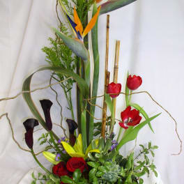 Tall tropical floral arrangement with birds of paradise, tulips, roses, and calla lilies