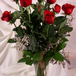 Red roses arranged in a clear glass vase