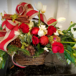 Basket arrangement with red roses, white flowers, and holiday ribbon