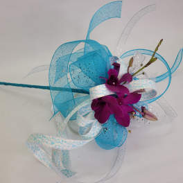 Purple orchid corsage with blue and white ribbon loops