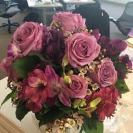 Pink roses and magenta flowers in a hand-tied bouquet