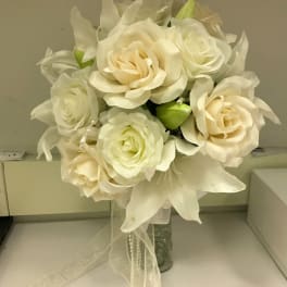 Cream rose bouquet with white lilies in a glass vase