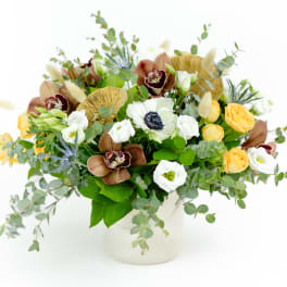 Mixed bouquet of white and yellow flowers in a white vase