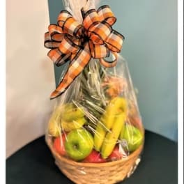 Basket of fruit wrapped in clear cellophane with a plaid bow