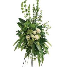 Tall standing floral spray with white roses and green foliage on a metal easel