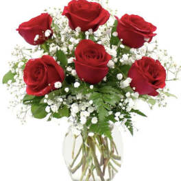 Bouquet of red roses and white baby's breath in a clear glass vase