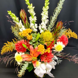 Colorful floral arrangement with lilies, snapdragons, and chrysanthemums in a vase