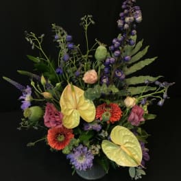 Mixed bouquet with purple, pink, and yellow flowers in a vase