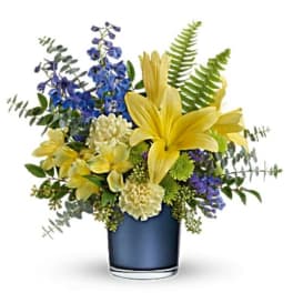 Yellow lilies and blue flowers in a dark vase