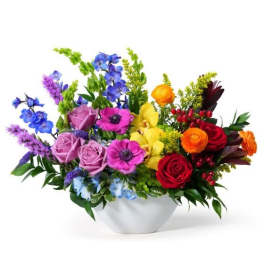 Colorful low flower arrangement in a white bowl-shaped vase