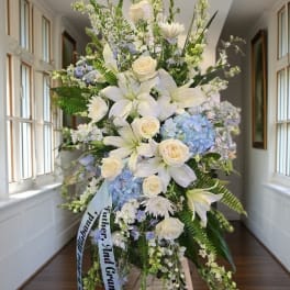 Large white and blue floral standing spray with lilies and roses