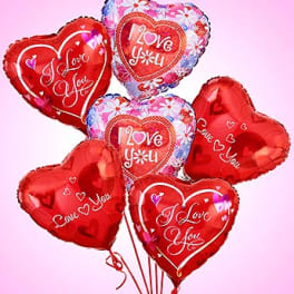 Cluster of heart-shaped red and floral balloons with love messages
