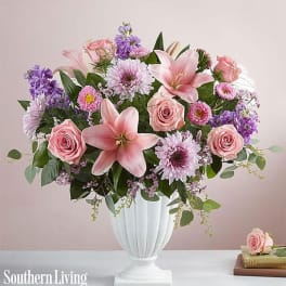 Pink and purple floral arrangement in a white vase