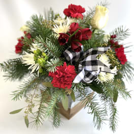 Holiday bouquet with red and white flowers in a box, tied with a plaid ribbon