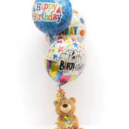 Birthday balloons with a teddy bear holding a party horn