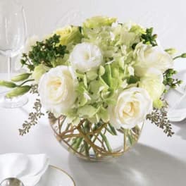 White and pale green floral centerpiece in a glass bowl vase