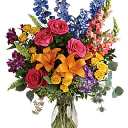 Colorful bouquet of roses, lilies, and snapdragons in a glass vase