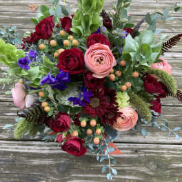 Bouquet of red and pink roses with purple blooms and greenery