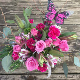 Pink roses and carnations with lilies and a butterfly pick