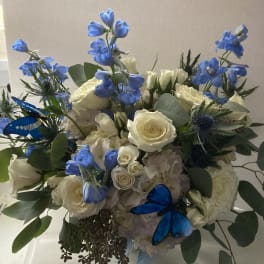 Bouquet of white roses and blue flowers with butterfly accents